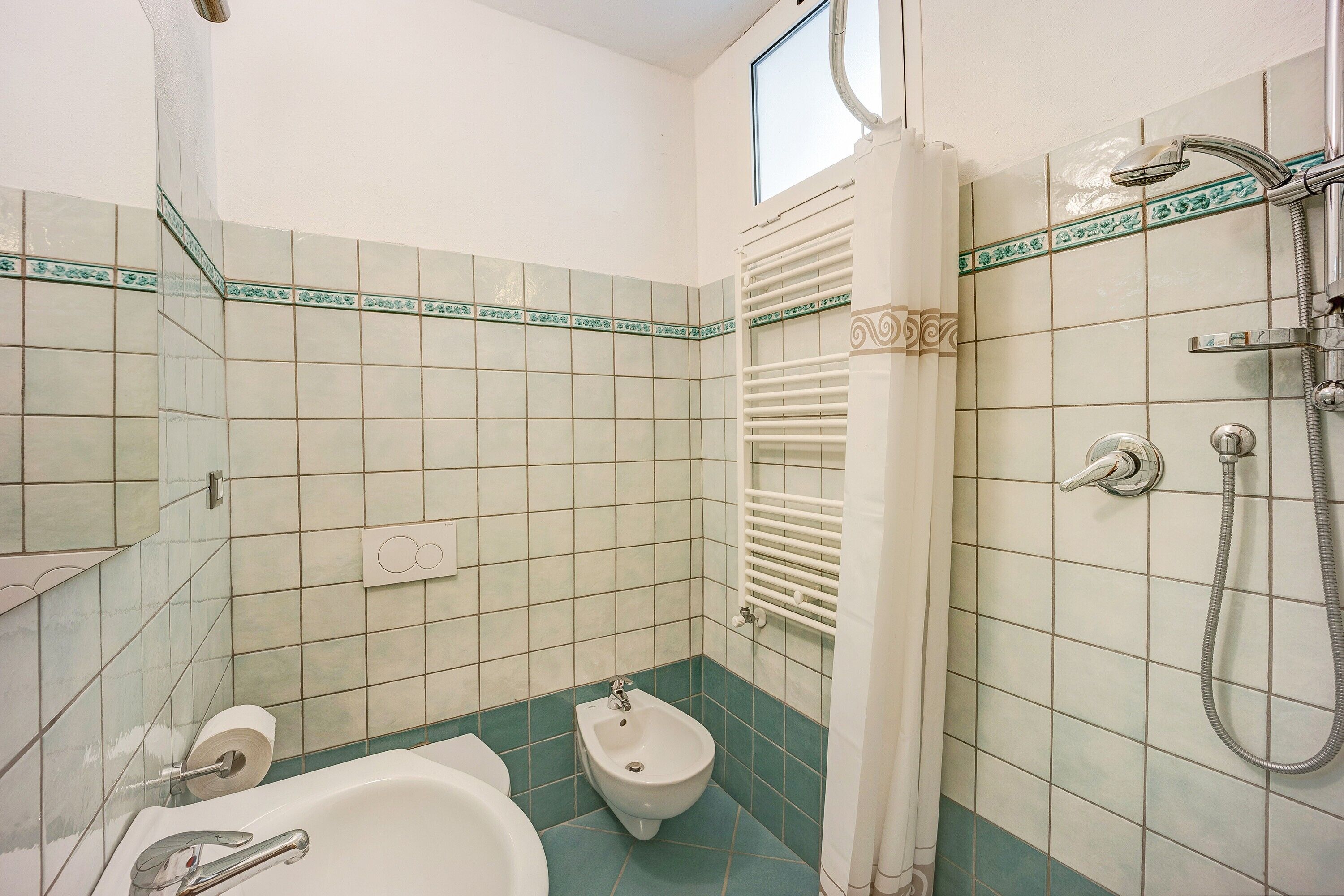 Een badkamer met een bad, toiletgondel en douche.