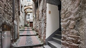 Un estrecho sendero de piedra que lleva a un edificio con una escalera y una puerta.