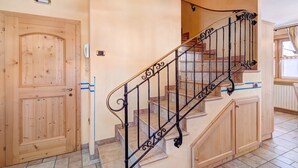 A wooden door, a staircase with ornate metal railings, and a light-colored wall. - Chalet Betty Apartment Sgembro with Mountain View (Livigno)