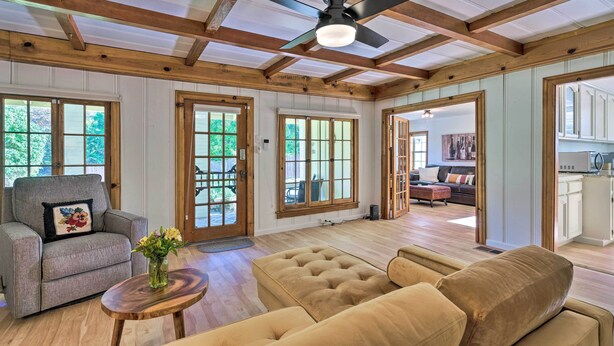 A spacious living room with wooden beams, a ceiling fan, and large windows. - Wine Country Escape w/ Hot Tub in River Pines! (River Pines)