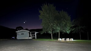 A building with a fenced area, a tree, and a clear sky. - YARRAWONGA PARK COTTAGE<br>Cozy 2 bedroom cottage on small acreage  (Mudgee)