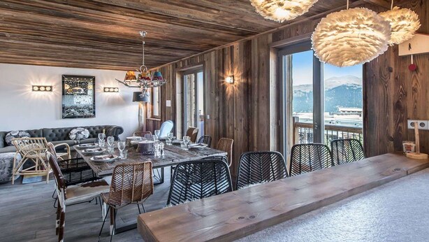 A rustic dining area with a long wooden table, black woven chairs, and large feathered pendant lights. - 4-bedroom apartment for 10 in central Courchevel 1850 (Courchevel 1850)