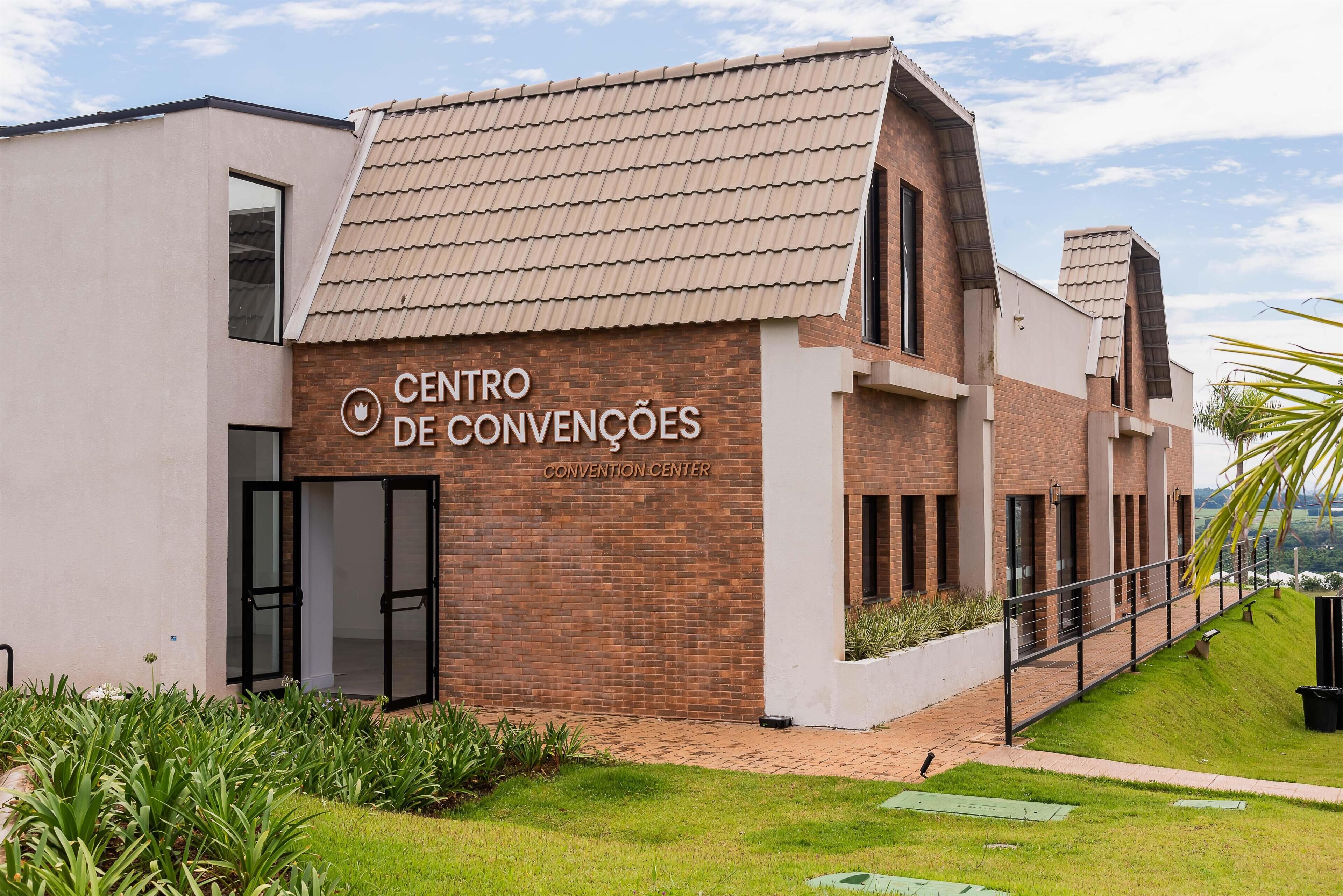 A modern building with a sign reading 'CENTRO DE CONVENÇÕES' and a brick facade.