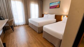 Una habitación de hotel con dos camas, un escritorio y una silla.
