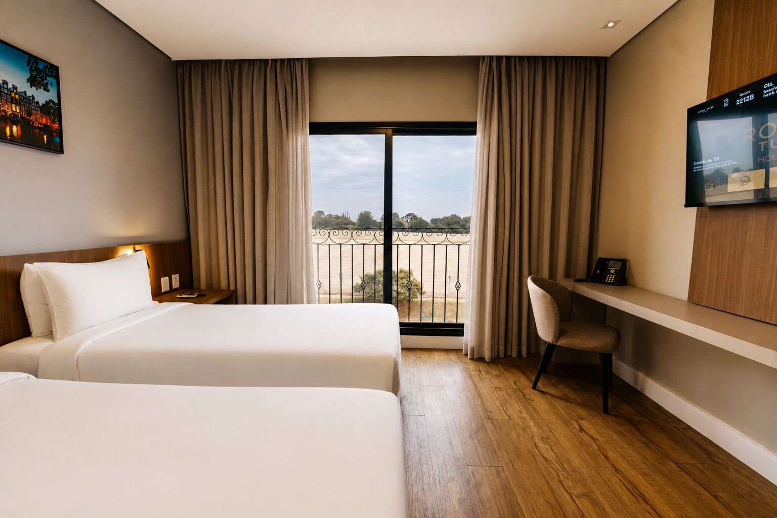 Habitación de hotel con dos camas, un escritorio, una silla, un televisor y un balcón con vistas.