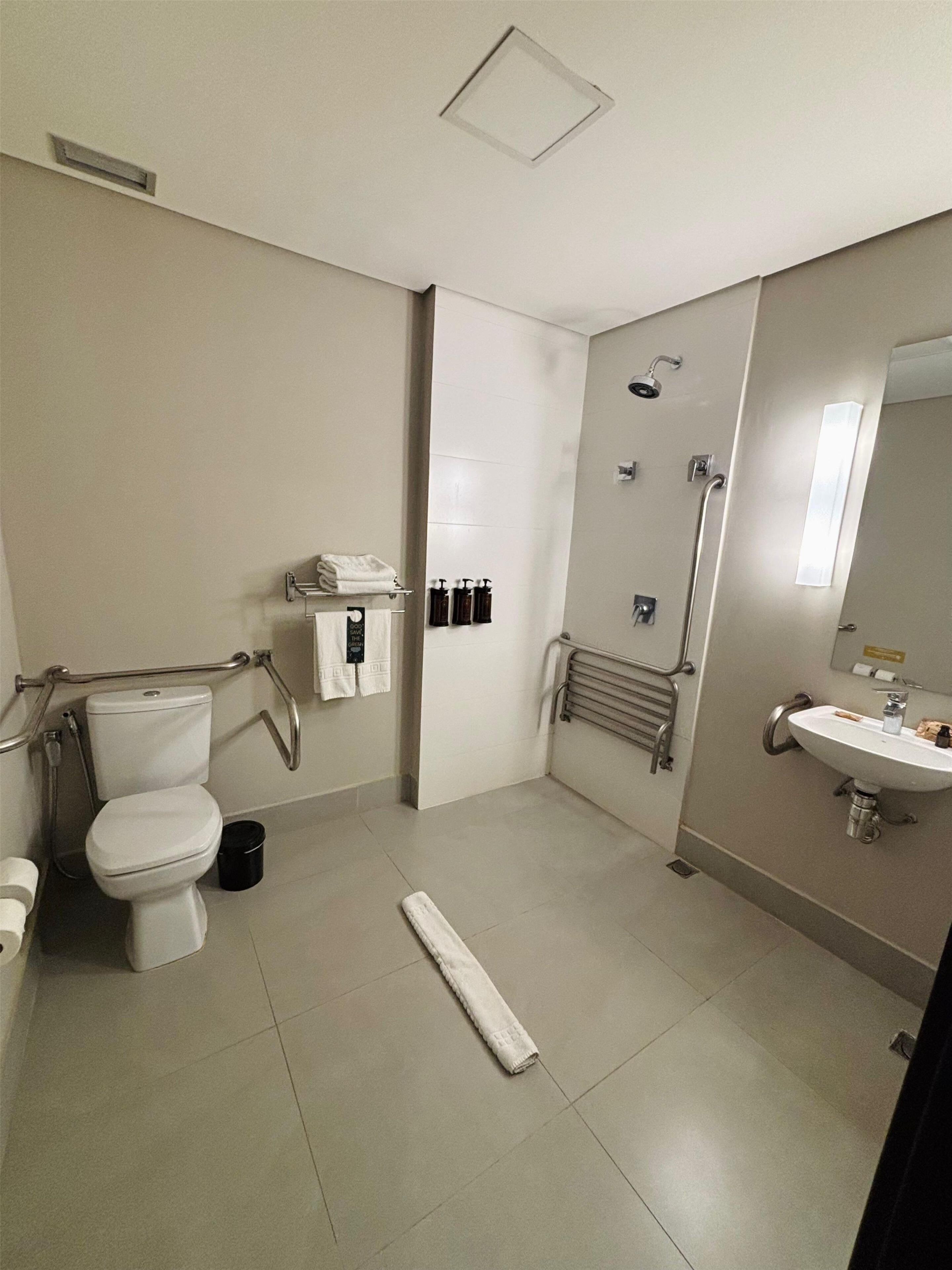 A modern bathroom with a toilet, bidet, shower, and sink.