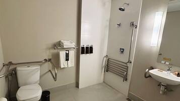 A modern bathroom with a toilet, bidet, shower, and sink.