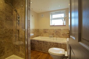 A bathroom with a shower, bathtub, and toilet.