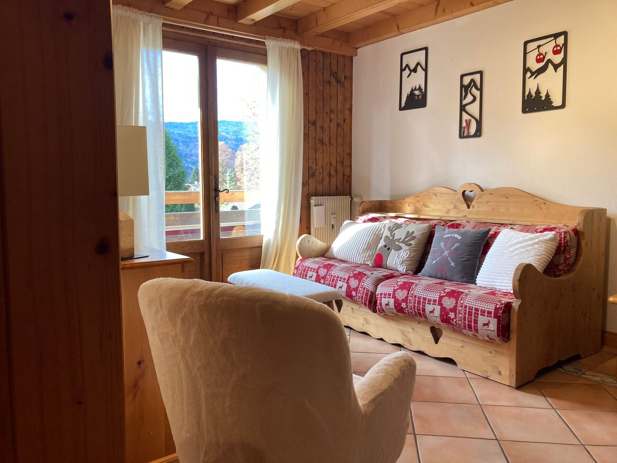 A cozy room with a wooden bed, a chair, and a window with curtains.