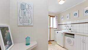 A kitchen with white cabinets, a dishwasher, and a window with a view. - Marengo Panoramic Ocean Views (Marengo)