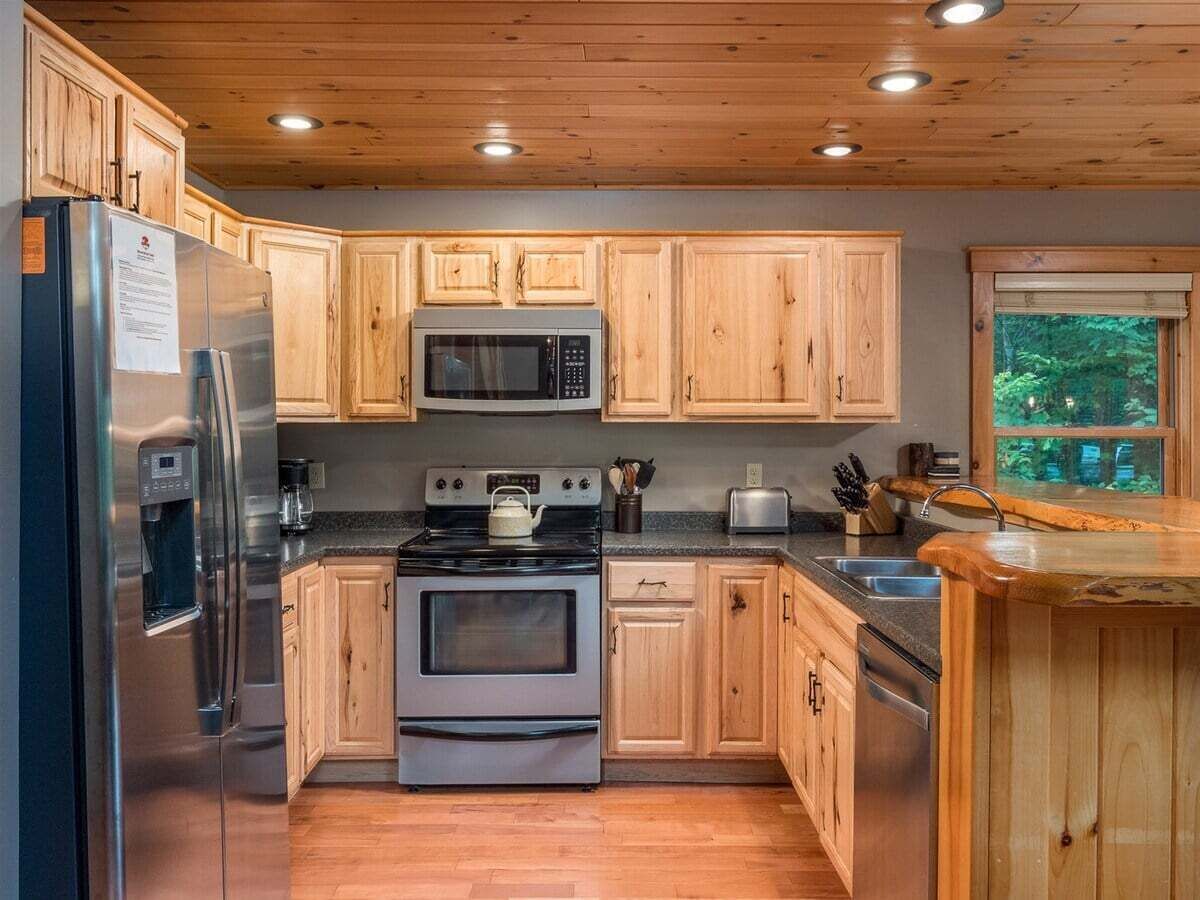 Una cocina con armarios de madera, electrodomésticos de acero inoxidable y una ventana con vistas.