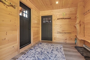 A wooden interior with two black doors, a patterned rug, and a sign indicating ski tips. - Chalet at The Peaks w/ Hot Tub and Trail Views! (Newry)