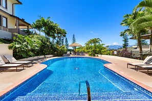 Ein Swimmingpool mit Liegestühlen und Palmen.