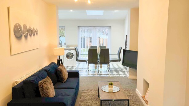 A living room with a sofa, a coffee table, a TV, and a dining area with chairs and a table. - *Exclusive* Modern, Stylish 3-bed, sleeps 6 -Birmingham,Solihull,NEC,Airport,HS2 (Birmingham)