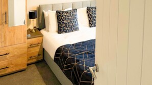 A hotel room with a bed, a wardrobe, a nightstand, and a sign that reads "HESTON". - *Exclusive* Modern, Stylish 3-bed, sleeps 6 -Birmingham,Solihull,NEC,Airport,HS2 (Birmingham)