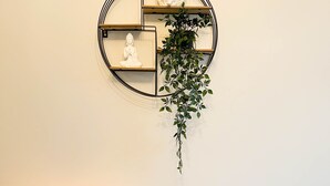 A dining table with a hanging plant and a small statue. - *Exclusive* Modern, Stylish 3-bed, sleeps 6 -Birmingham,Solihull,NEC,Airport,HS2 (Birmingham)
