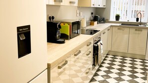 A modern kitchen with a checkered floor, a water dispenser, and a skylight. - *Exclusive* Modern, Stylish 3-bed, sleeps 6 -Birmingham,Solihull,NEC,Airport,HS2 (Birmingham)
