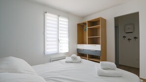 A bedroom with a bed, a wardrobe, and a bathroom door. - Equiped house for 4 adults and 4 children (Le Bois-Plage-en-Ré)