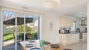 A modern kitchen with white cabinets, a built-in microwave, and a stainless steel range hood. - House for 4 adults / 4 children, fully equipped (Piriac-sur-Mer)