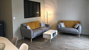 A modern living room with two grey sofas, a white coffee table, and a floor lamp. - Sunny appartment for 6 people (Le Bois-Plage-en-Ré)