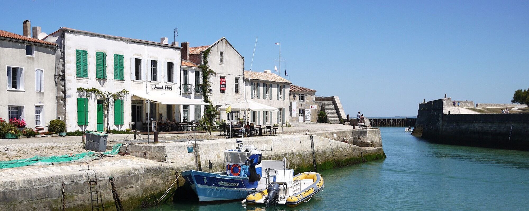 A waterfront building with a restaurant, a narrow waterway, and boats docked.
