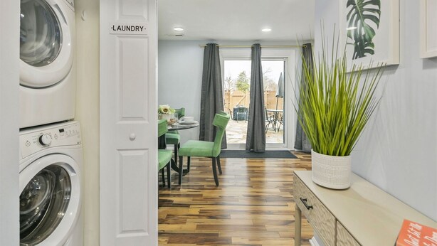 A laundry room with a door labeled "LAUNDRY" leading to a dining area with a table and chairs, a potted plant, and a view of the outside. - GannonHeights: Work-Friendly & 40 mins to DC (Sterling)