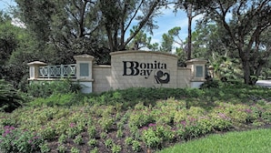 Ein Schild für Bonita Bay mit einem angelegten Garten davor.