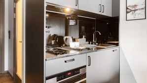 Une cuisine moderne équipée d’appareils électroménagers en acier inoxydable, d’un four encastré et d’une machine à café.