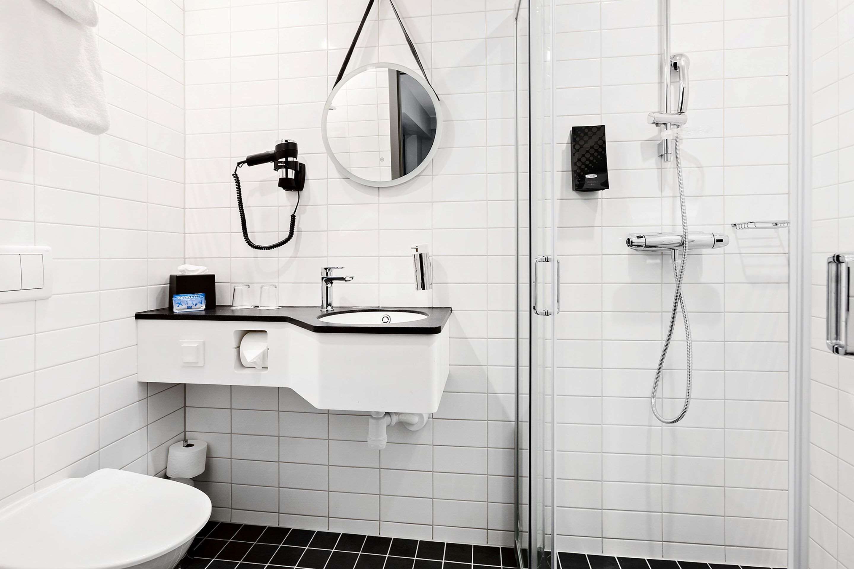 A modern bathroom with a toilet, sink, and shower.