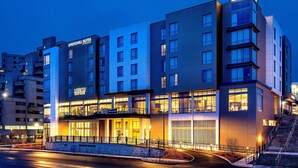 Ein mehrstöckiges Hotel mit Hinweisschildern für 'Springhill Suites' und 'Mission Beach House'.
