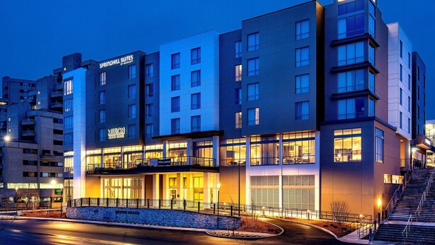Un hôtel à plusieurs étages, avec des panneaux indiquant « Springhill Suites » et « Mission Beach House ».
