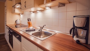 A modern kitchen with wooden countertops, a stainless steel sink, and a coffee maker. - Int Corner 7 (Krummhörn)