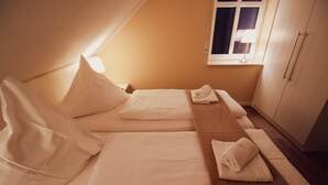Una habitación de hotel con dos camas, una ventana y un armario.
