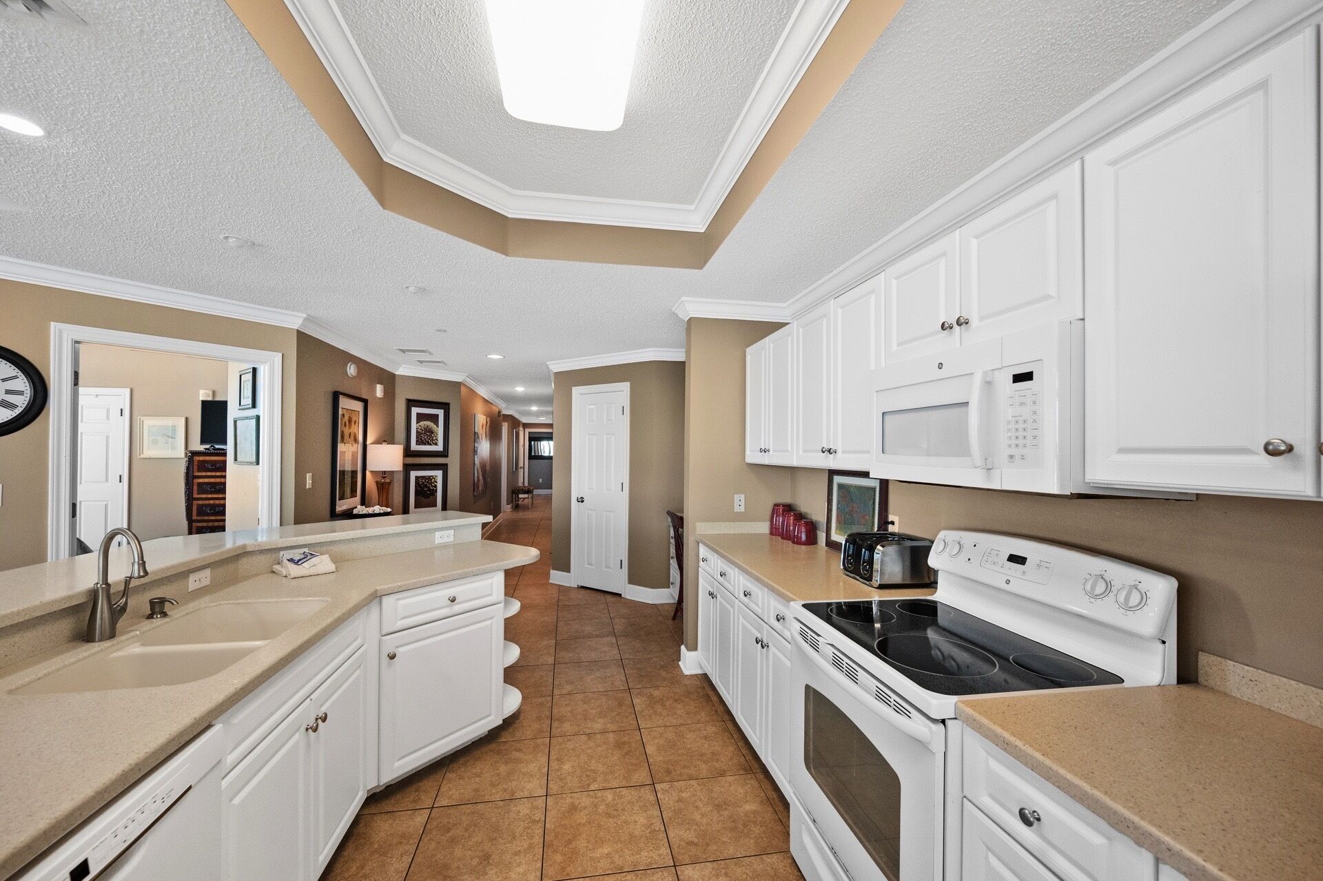 A modern kitchen with white cabinetry, a built-in oven, and a microwave.
