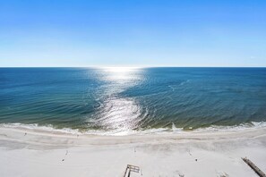 A beach with a clear view of the ocean and a sandy shore.