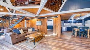 Relax in a cozy living space with a comfortable sofa, wooden coffee table, and a staircase leading to an upper level.