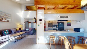 Ein modernes Interieur mit Wohnbereich, Küche und Barbereich.