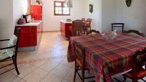 A spacious room with a kitchen area, a dining table with chairs, and a large window providing natural light. - Prestige villa with pool and jacuzzi (LE MOULE)