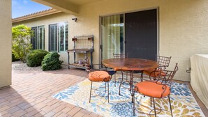 An outdoor patio with a round table and chairs, a decorative rug, and a pergola structure. - Modern Anthem Allure - Perfect Home Away From Home (Anthem)