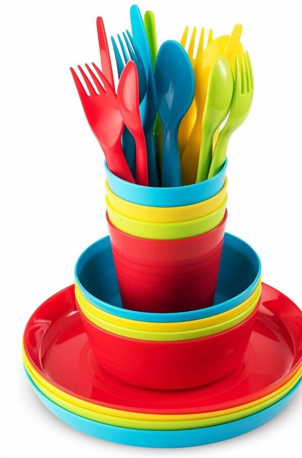 A stack of colorful plastic utensils and plates.