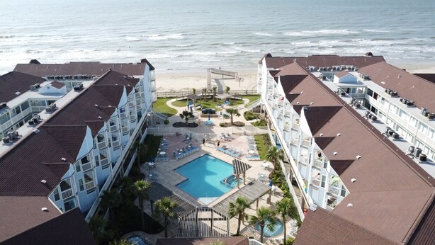 A hotel with a pool, beach access, and multiple balconies. - Newly renovated beautiful Oceanfront Oasis with direct beach access! HEATED POOL (Galveston)