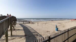 A wooden boardwalk leading to a sandy beach with a clear view of the ocean. - Newly renovated beautiful Oceanfront Oasis with direct beach access! HEATED POOL (Galveston)