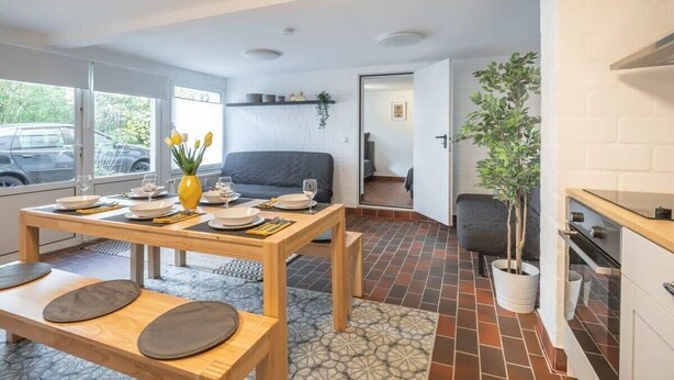Une cuisine moderne avec un coin repas, un canapé et une plante en pot.