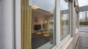 Een modern interieur met een open haard, zithoek en grote ramen.