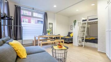 Una sala moderna con sofá, mesa de comedor y litera.