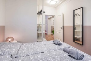 A bedroom with a bed, a bedside lamp, a mirror, and a wardrobe. - Charming Apartment in prime location (Hamburg)