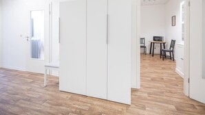 Une pièce comprenant une armoire, une chaise et une table avec des chaises.
