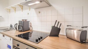 Une cuisine moderne équipée d’une cuisinière intégrée, d’une machine à café et d’un grille-pain.
