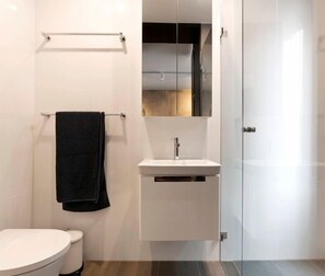 Bathroom features a pedestal sink, toilet, and glass shower enclosure.