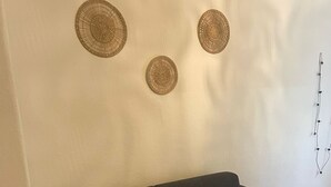 Een donkere bank tegen een witte muur, met drie ronde decoraties.